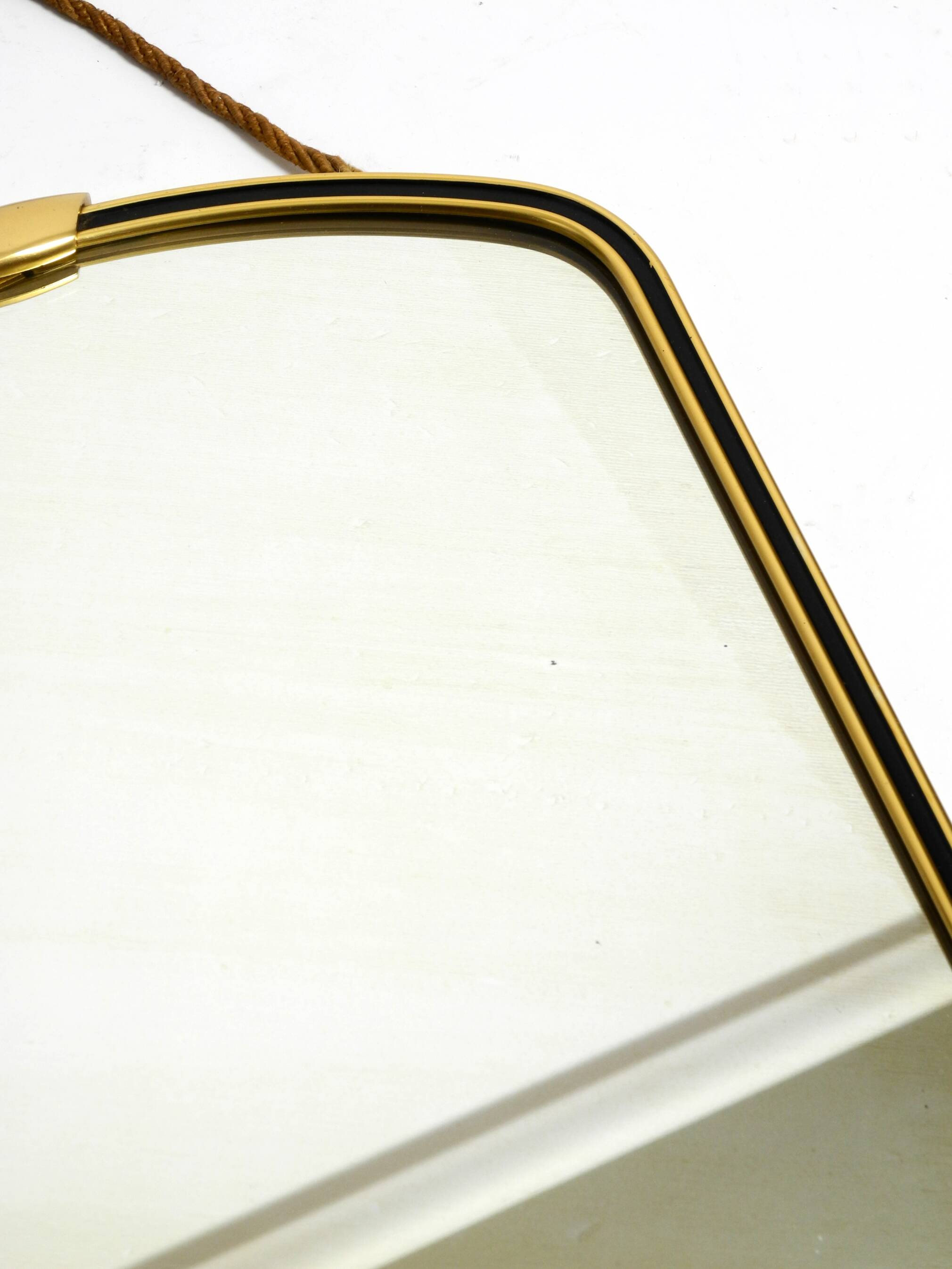 Beautiful small mid-century brass wall mirror with braided hanging strap