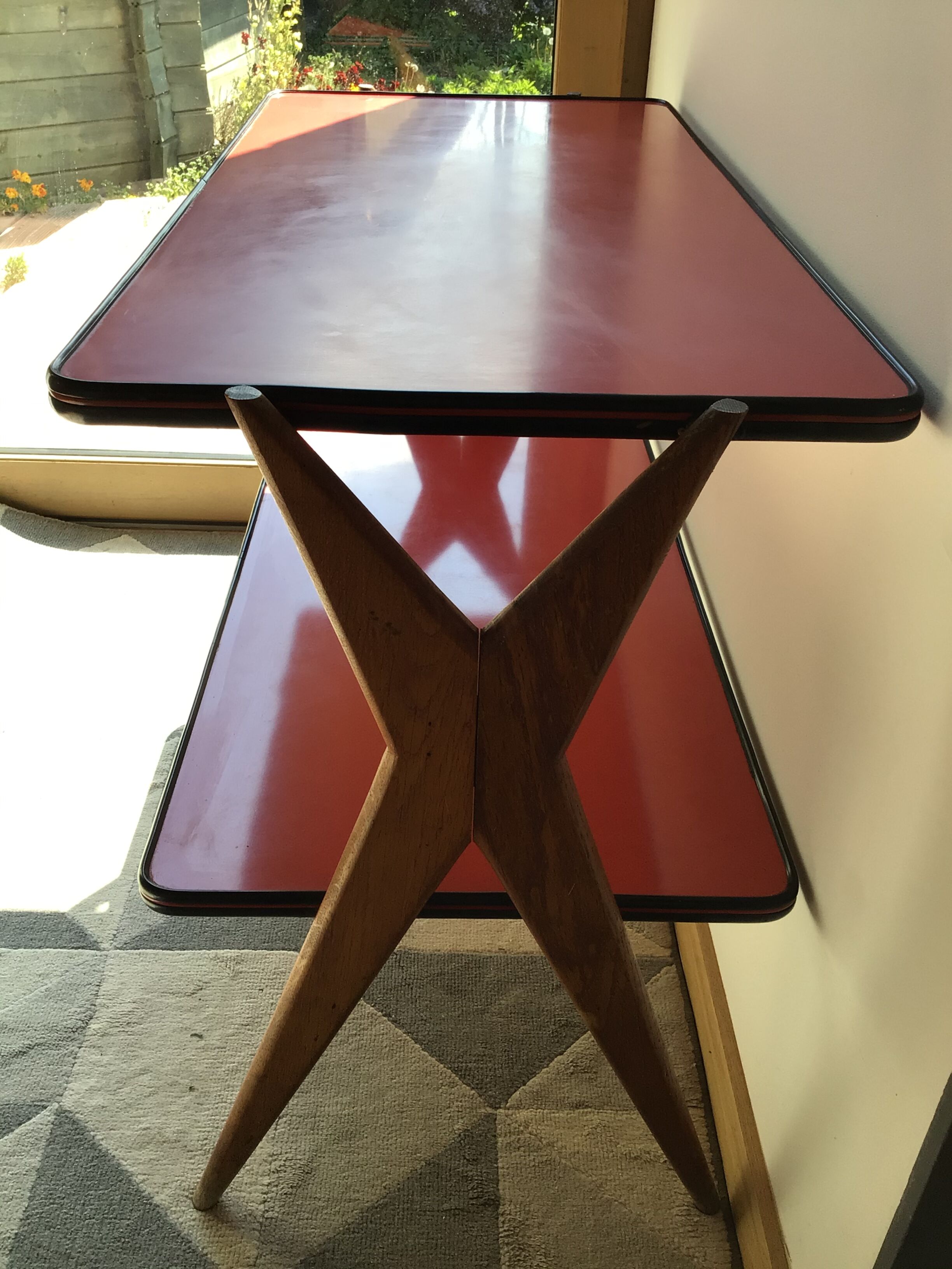 Double-footed red Formica wood spindles console