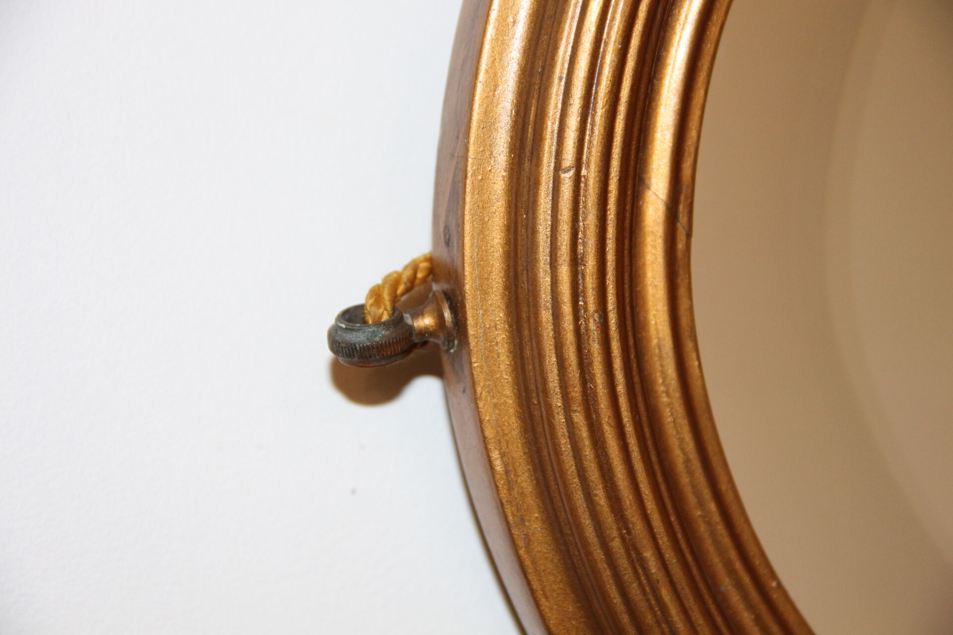 Beveled oval mirror in gilded wood