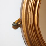 Beveled oval mirror in gilded wood