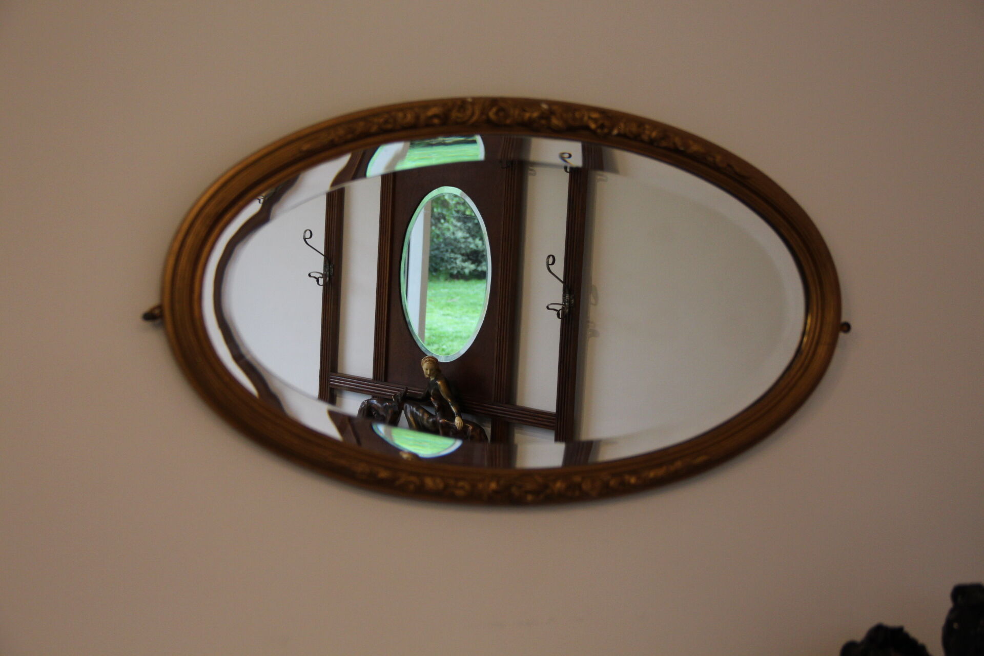 Beveled oval mirror in gilded wood