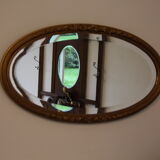 Beveled oval mirror in gilded wood