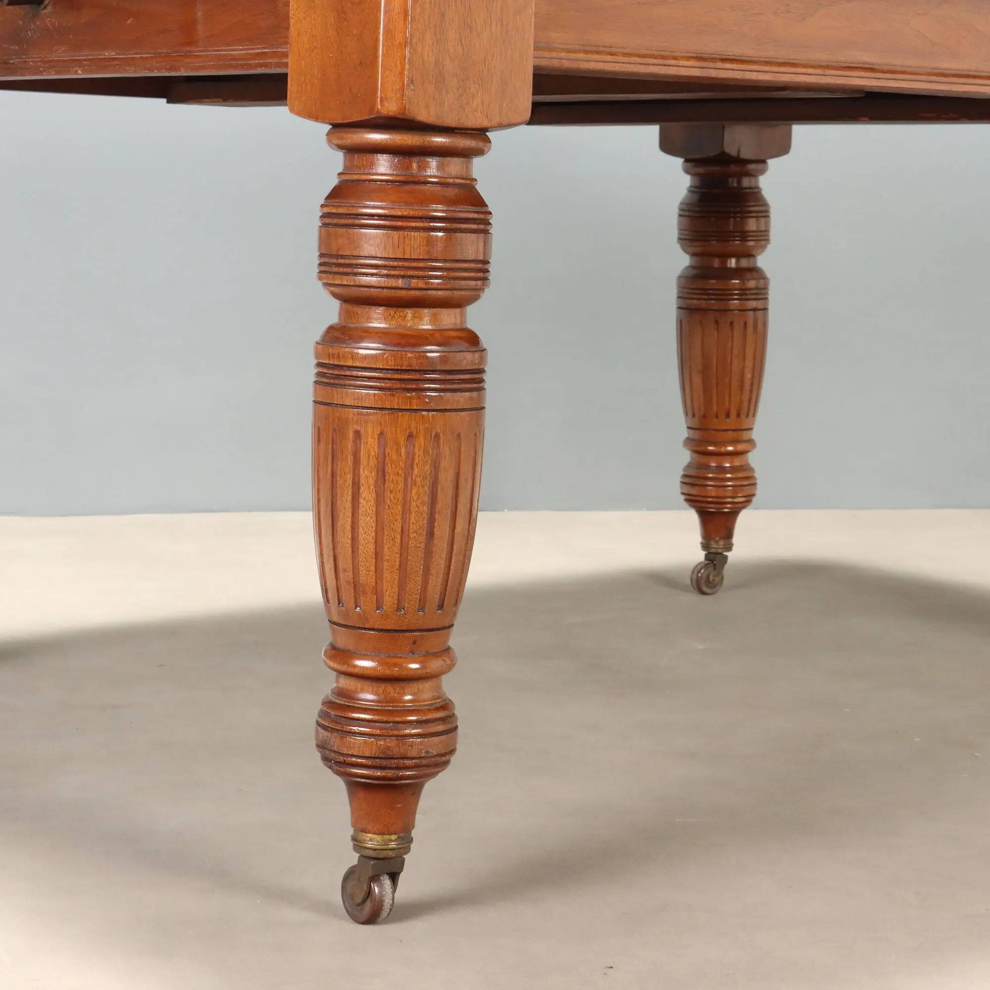 Antique extendable mahogany table with a crank mechanism, United Kingdom.