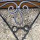 Old wrought iron console with a fleur-de-lis design.