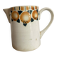 Old ceramic pitcher with orange decoration.