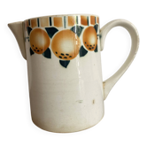 Old ceramic pitcher with orange decoration.