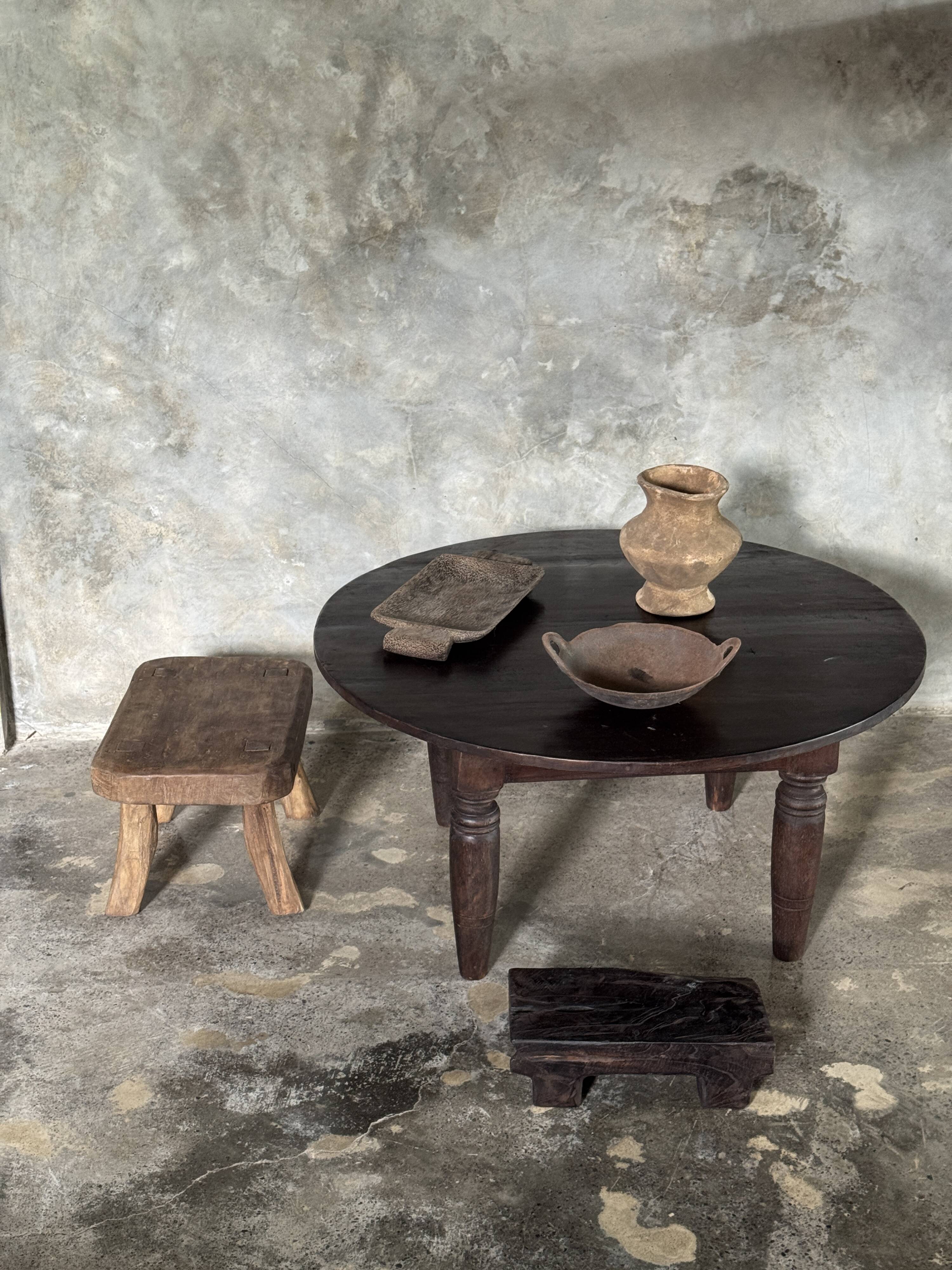 Antique round coffee table in Indonesian teak with turned legs.