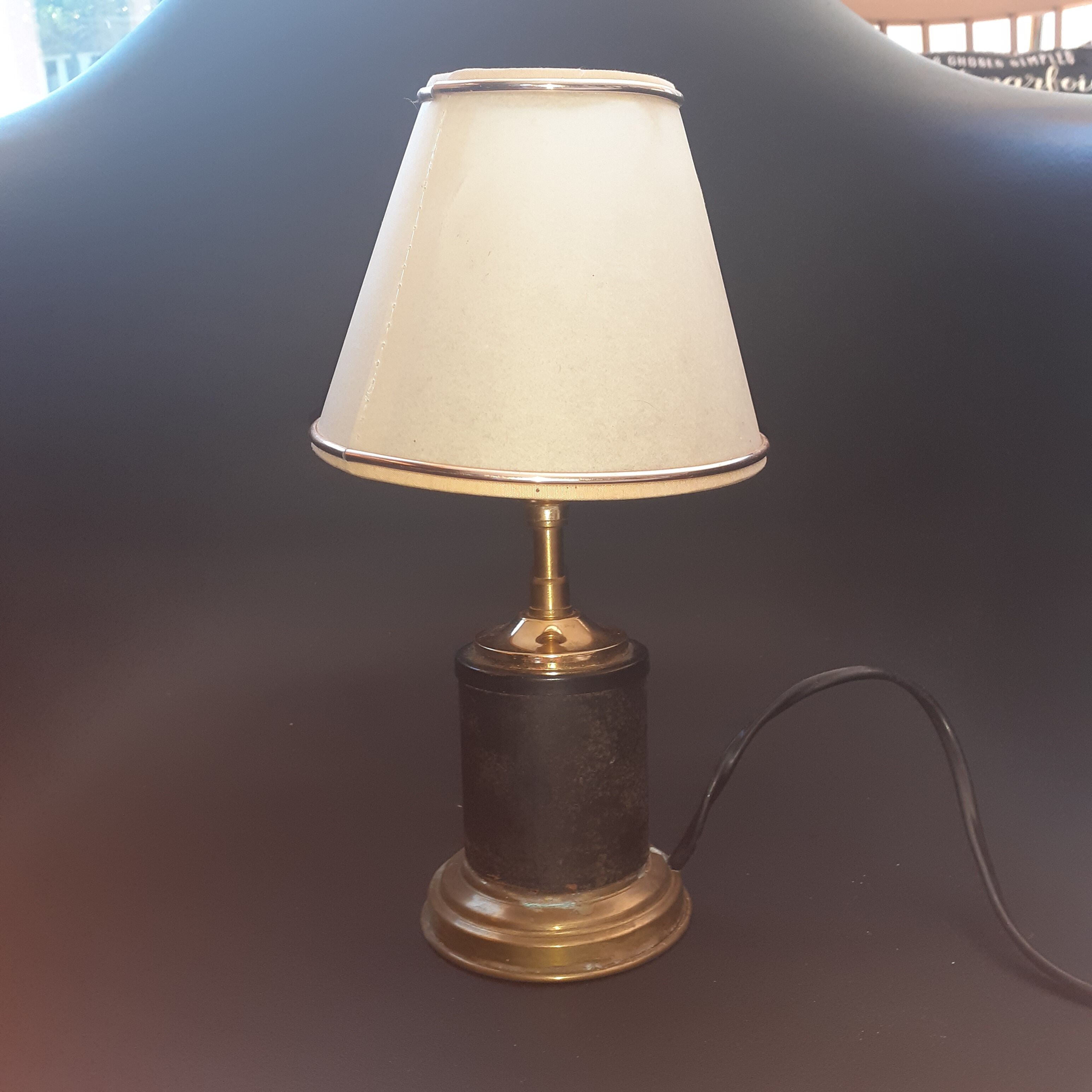 Antique lamp in black and gold metal with its lampshade