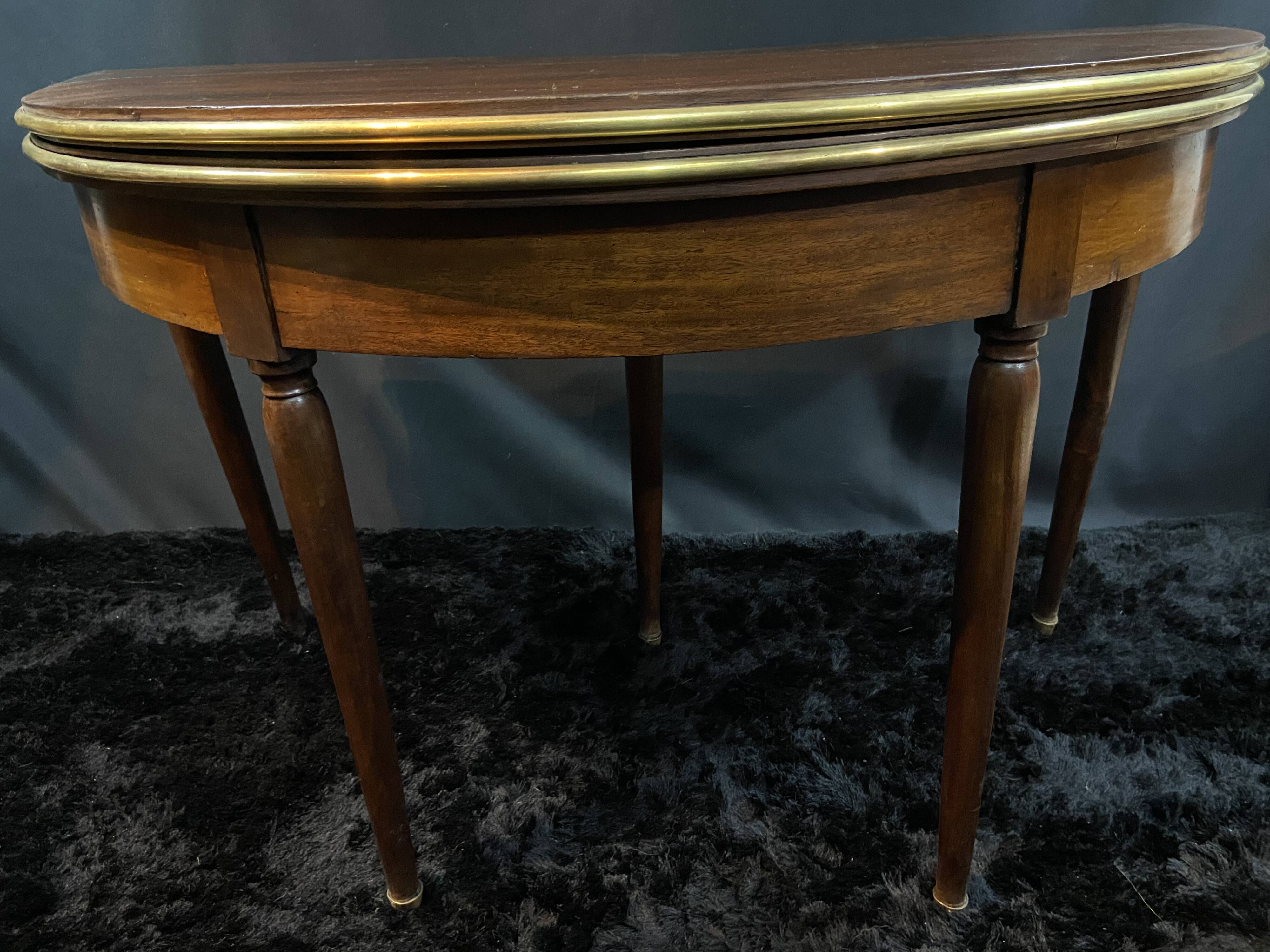 A Louis XVI period mahogany half-moon table forming a console/games table