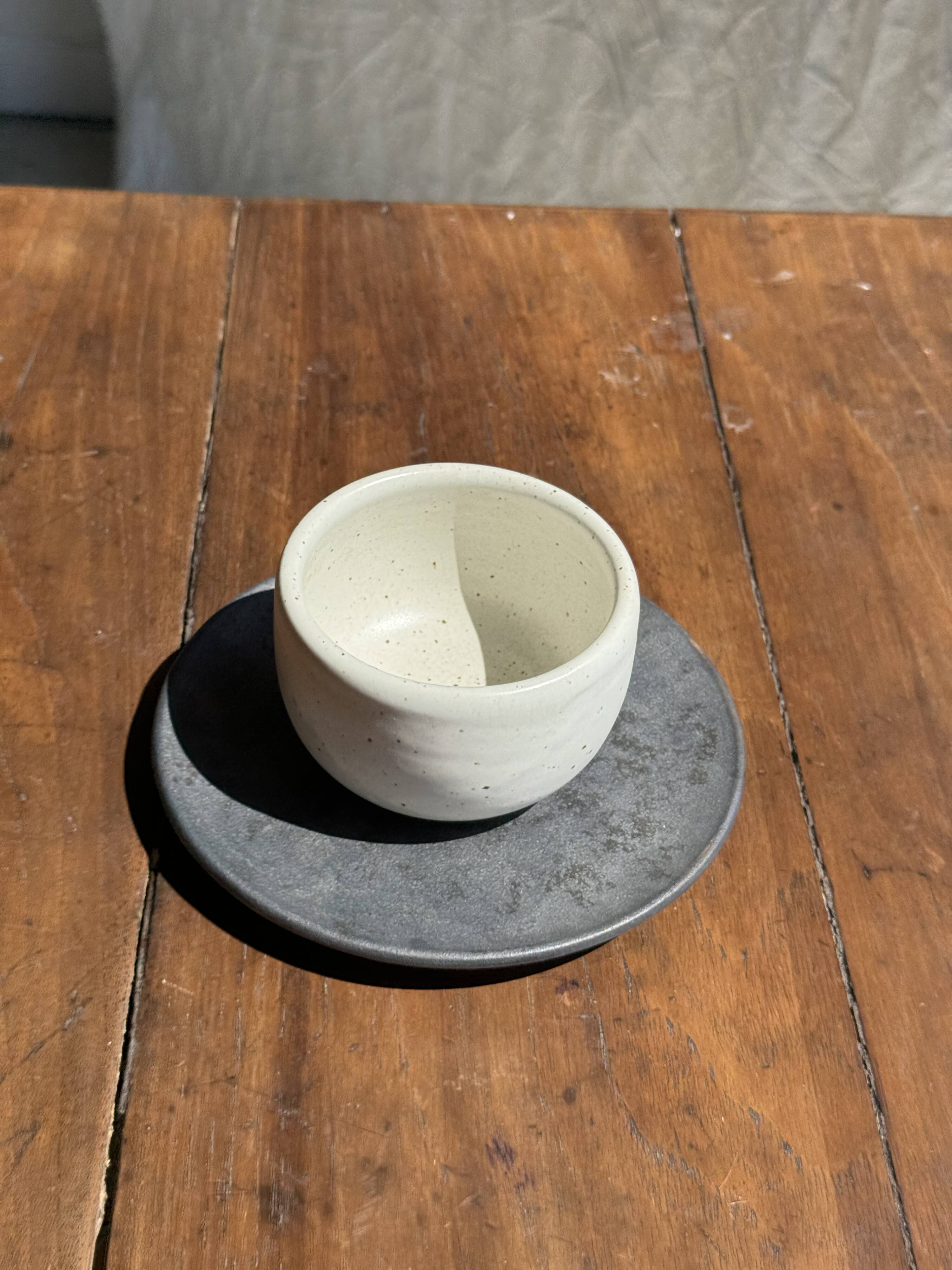 White Indonesian ceramic cup and gray saucer