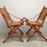 Pair of folding chairs in bamboo and caning, leather and brass