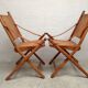 Pair of folding chairs in bamboo and caning, leather and brass