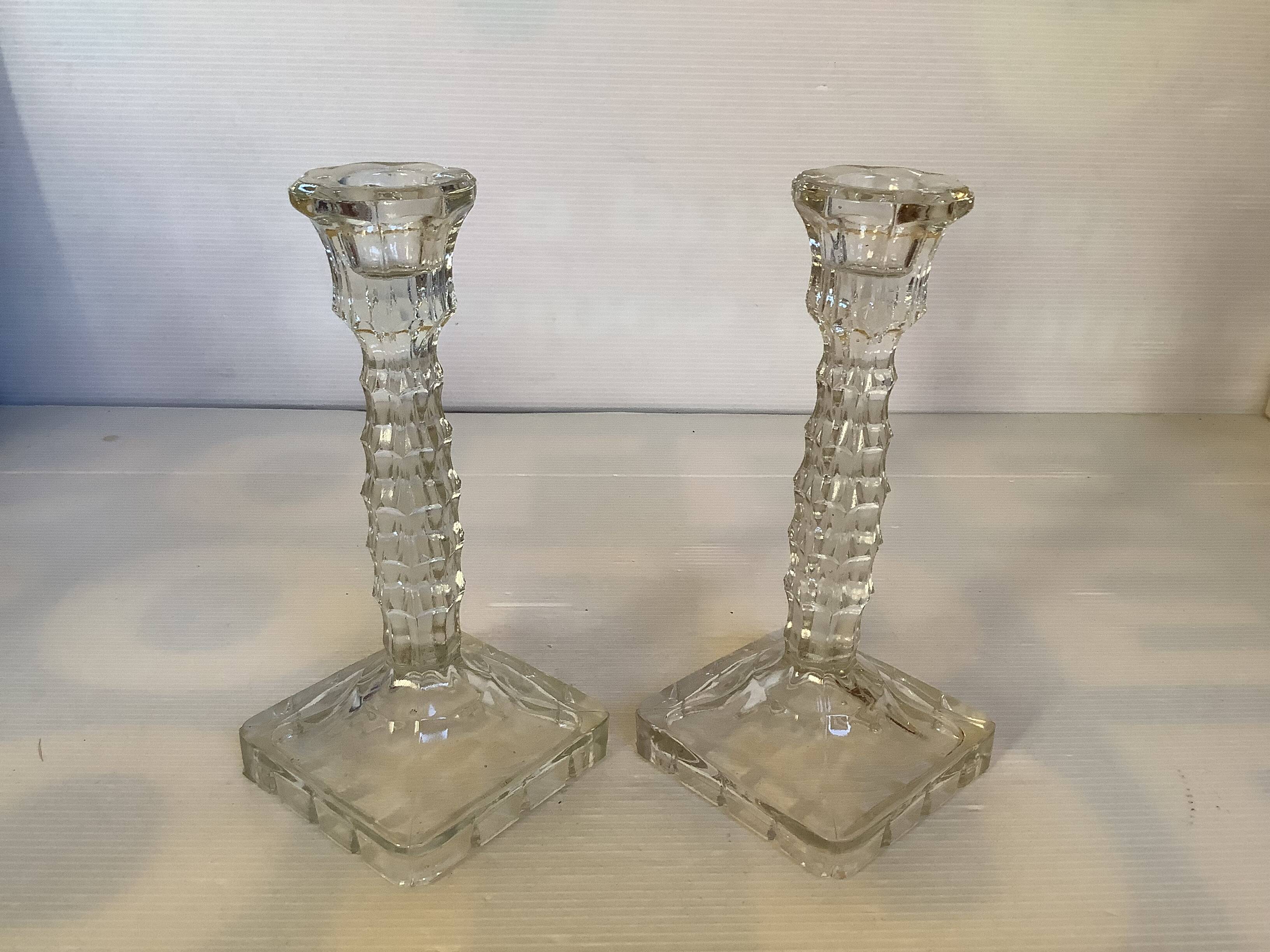 Pair of tall candle holders in the shape of a flower with a square base.