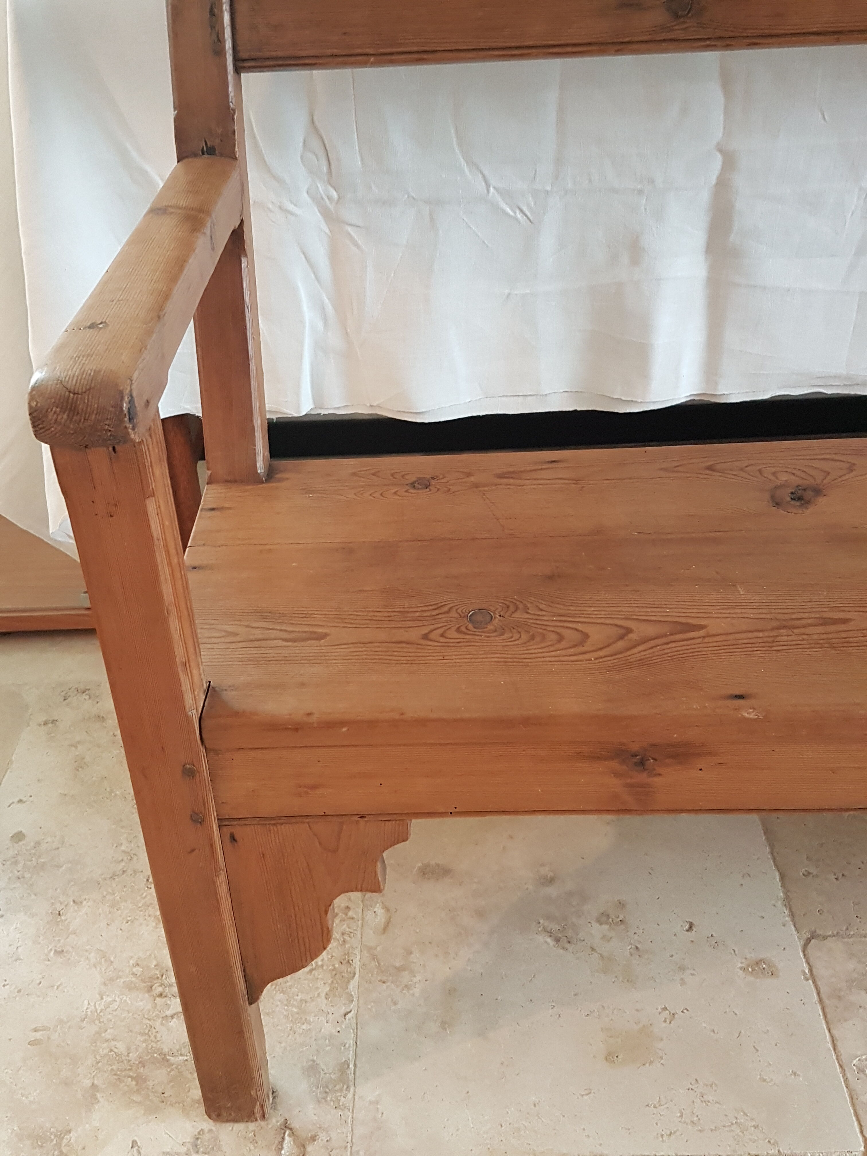 Church bench in fir tree with armrests