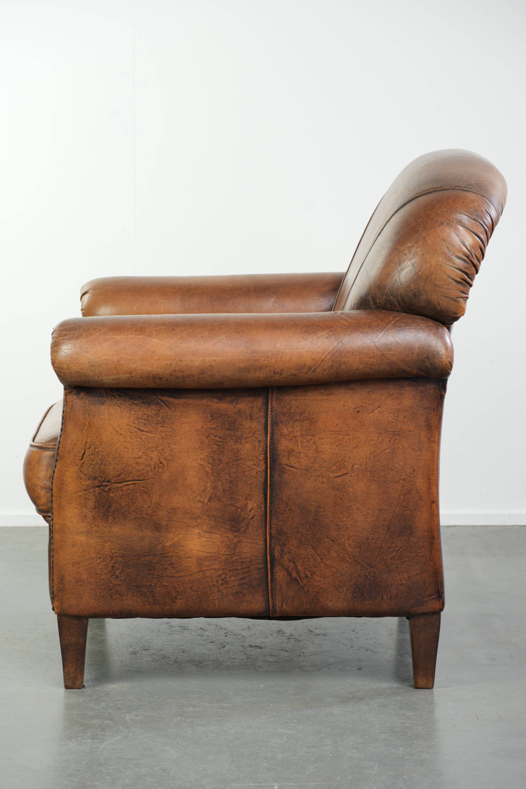 Comfortable characterful sheepskin armchair finished with decorative nails