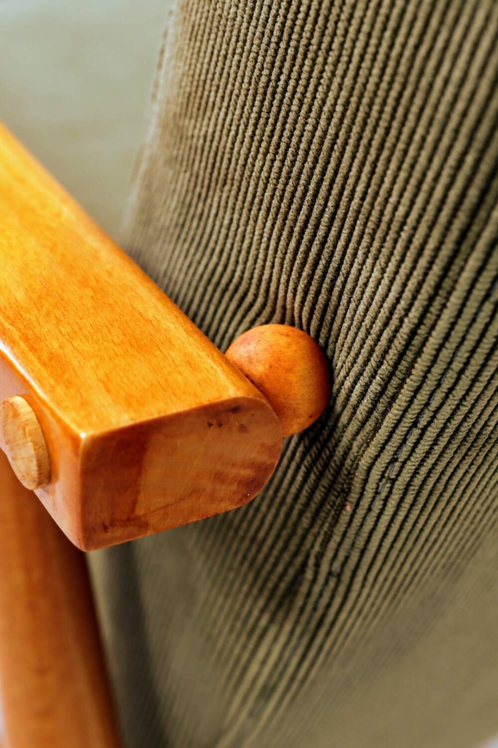 Mid-century modern design armchair in olive green corduroy.