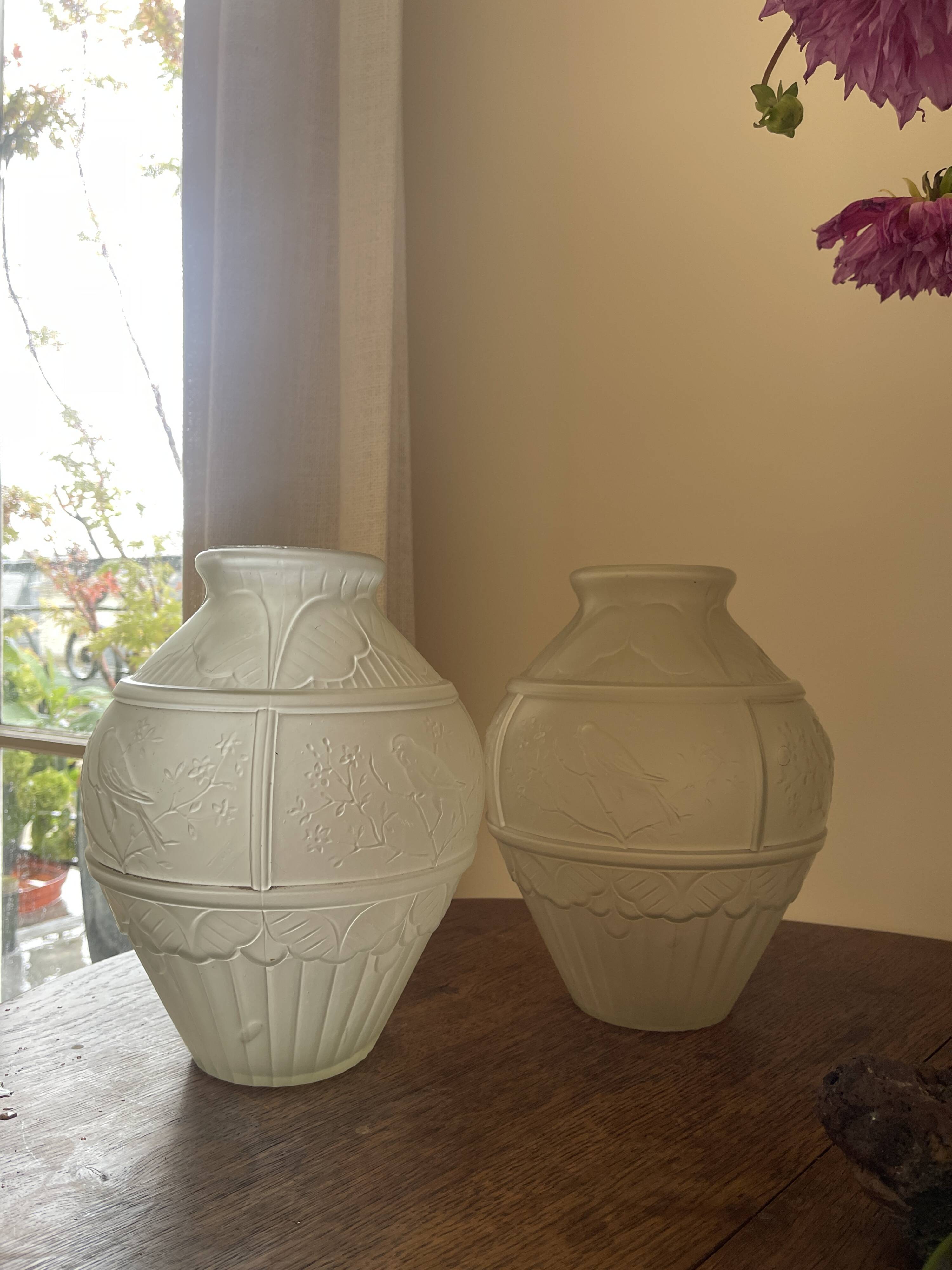 2 semi-opaque glass vases with relief bird designs.