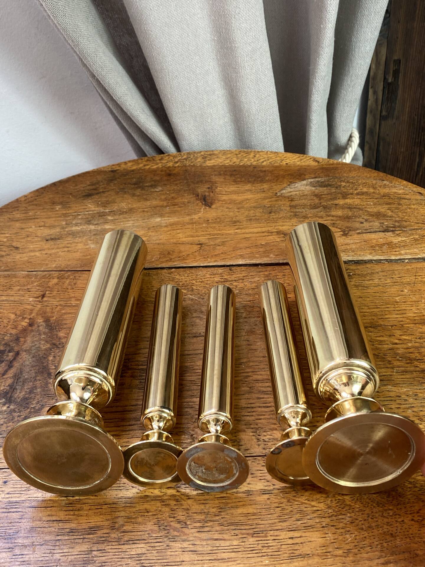 Set of candlesticks and tubular vases in solid brass.
