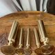 Set of candlesticks and tubular vases in solid brass.