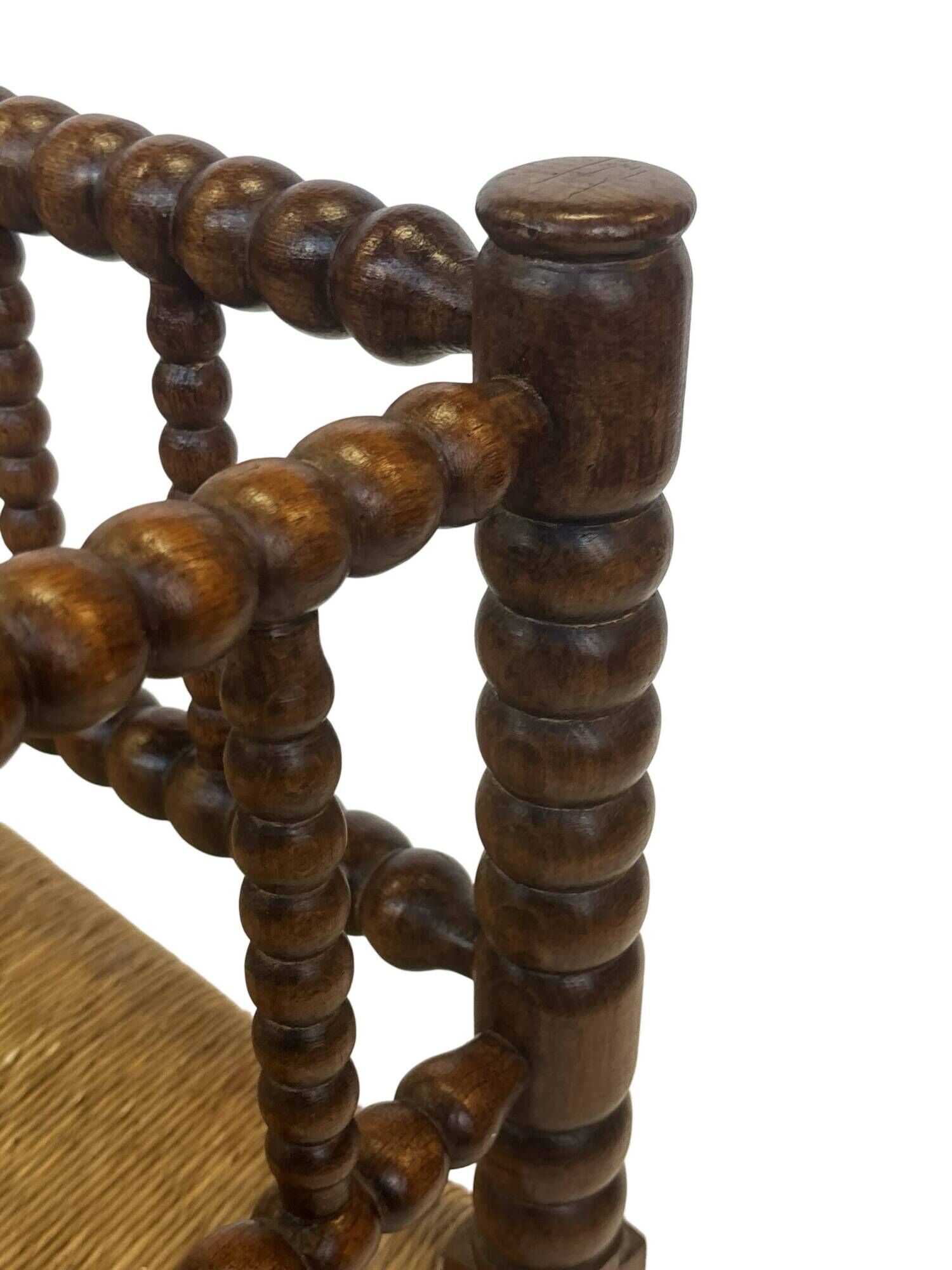 Vintage 'bobbin' bench with a rush seat, 1920s design with armrests.