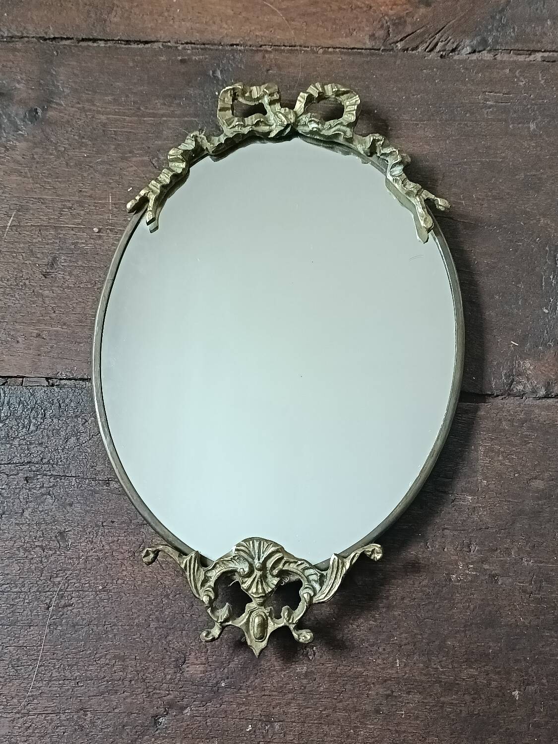 Antique mirror, oval with brass crest