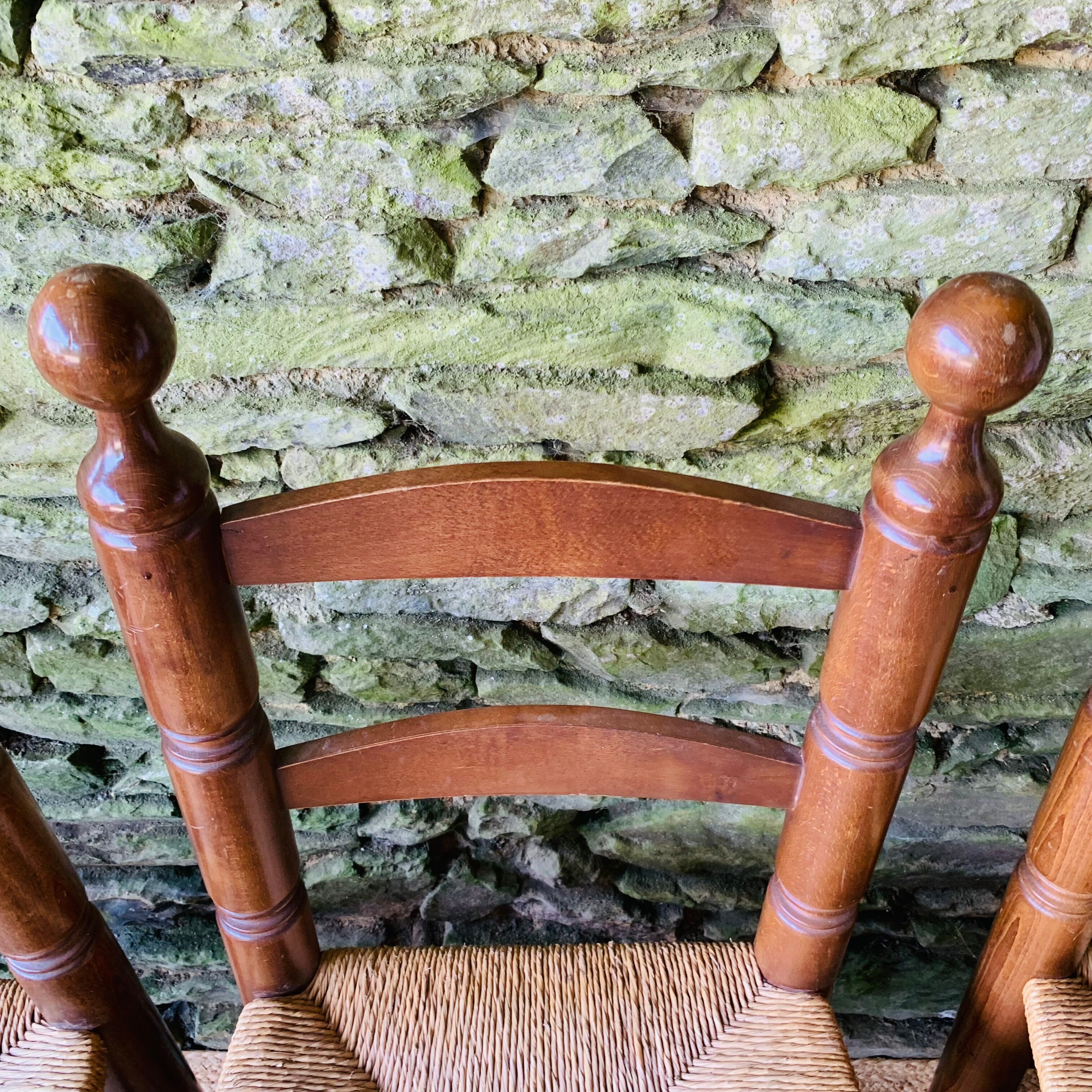 Set of 4 solid wood chairs with straw seats.