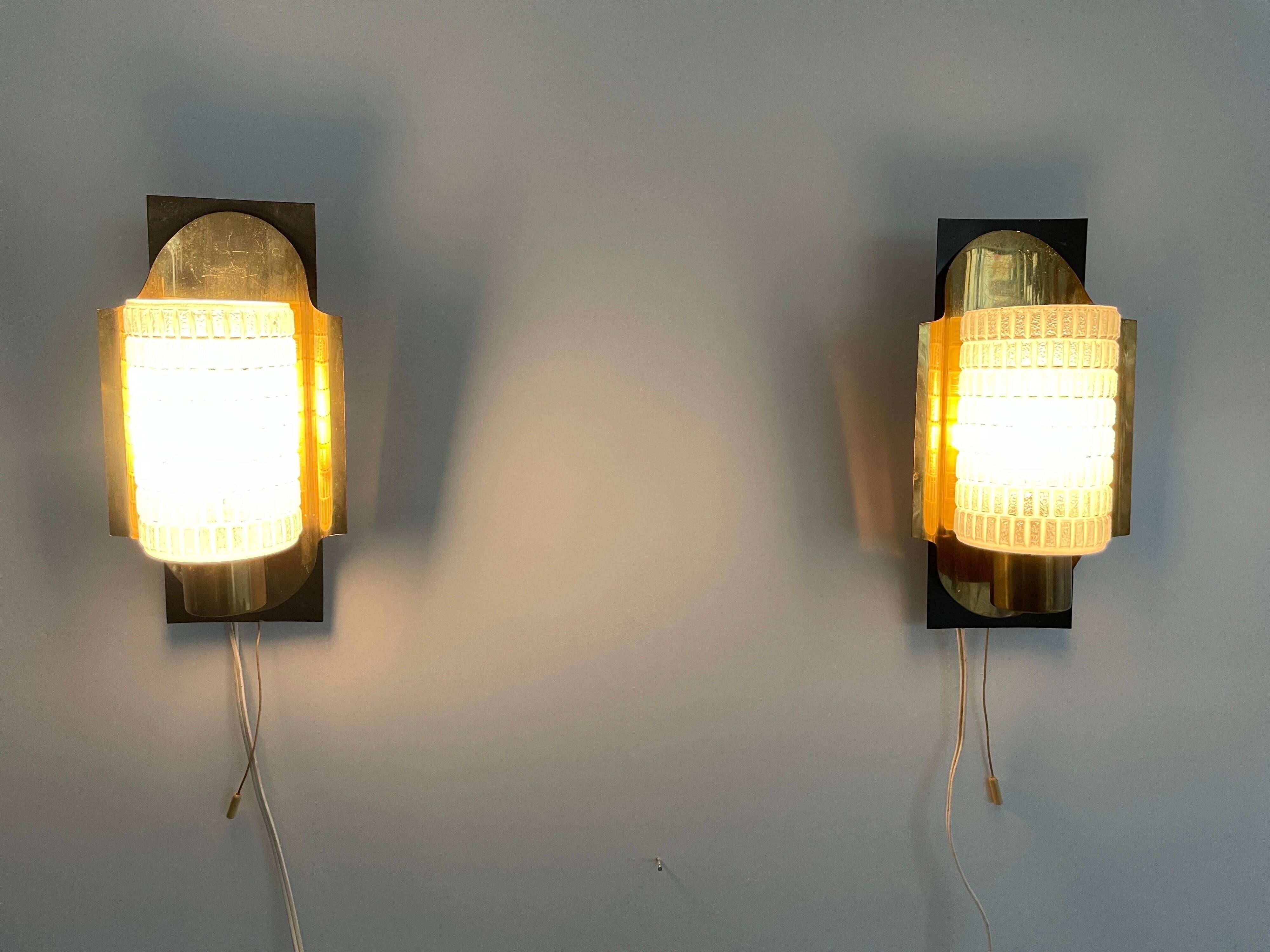 Mid-century pair of wall sconces in textured glass and brass, 1950s, Germany.