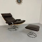 Vintage leather reclining armchair and its 1970s designer ottoman.