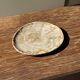 Small oval beige petrified wood dish or tray with speckled edges.