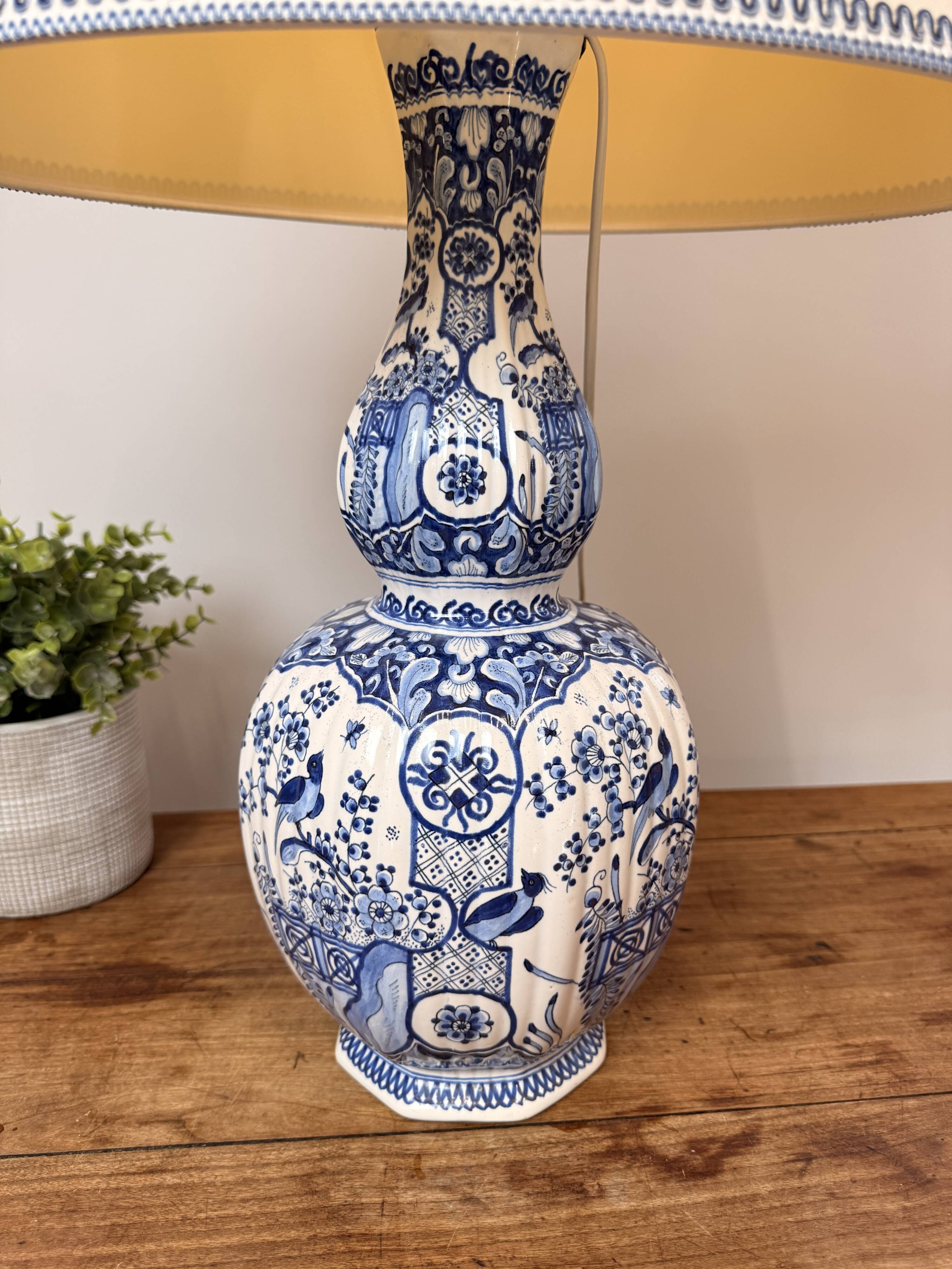 Blue and white Delft ceramic table lamp decorated with birds and flowers.