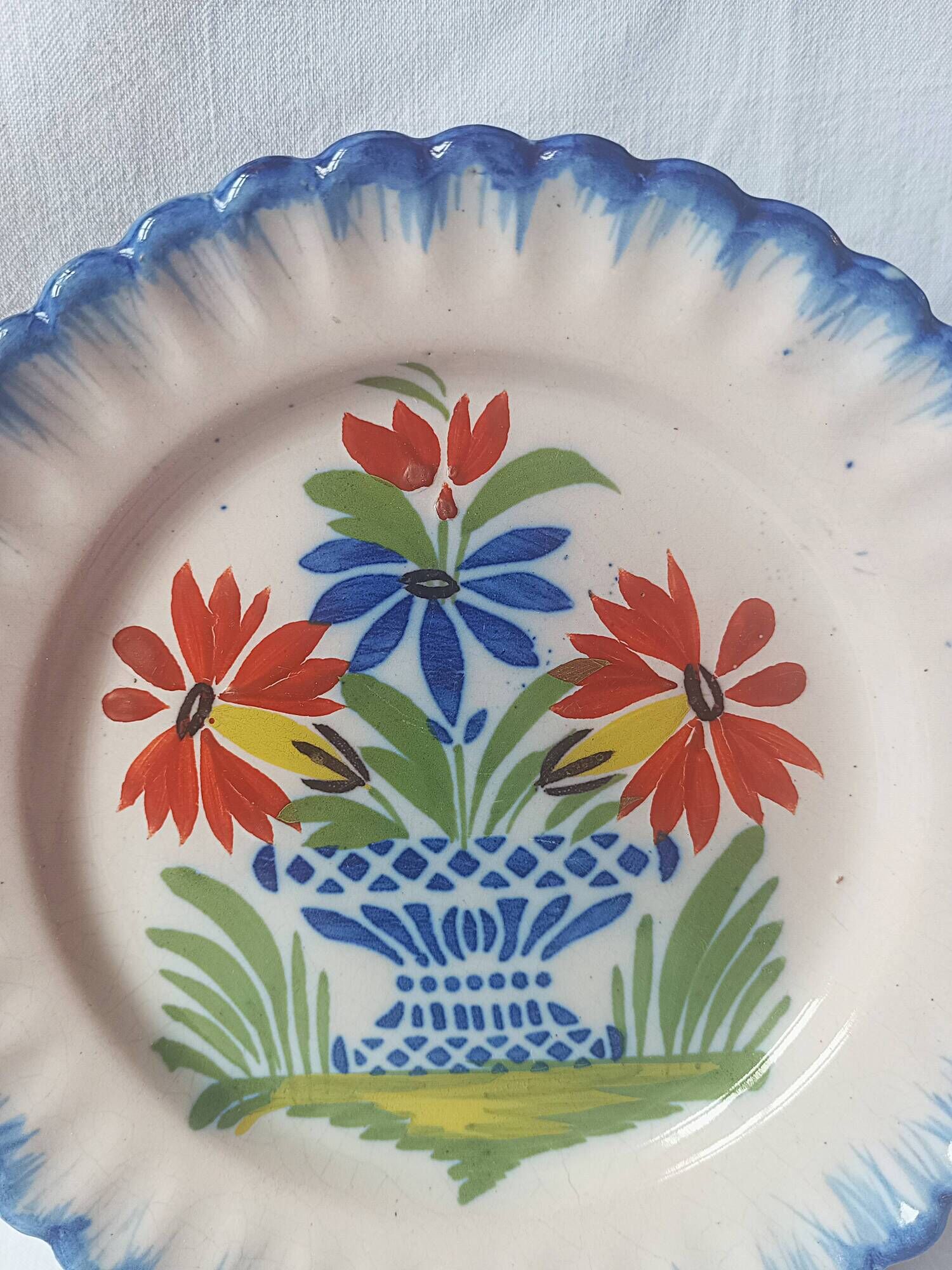 Pair of antique plates in popular earthenware with a floral basket decoration on the edge.