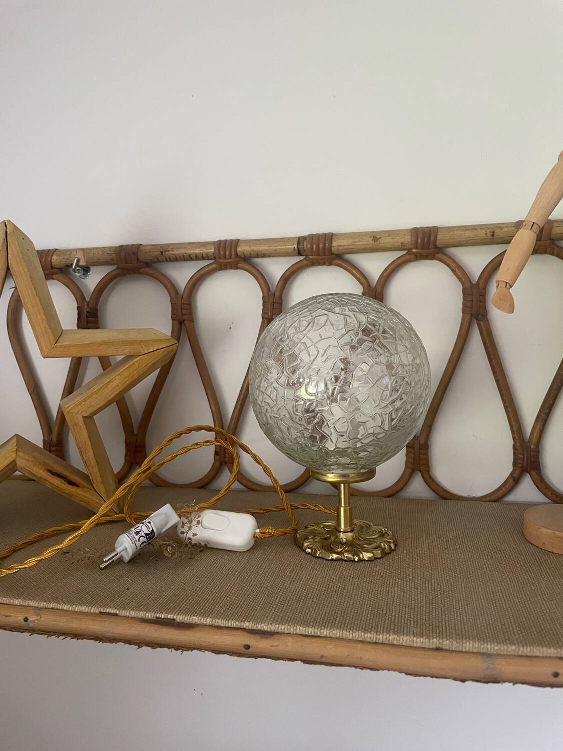 Small handcrafted globe lamp with a cracked finish and a golden brass base.