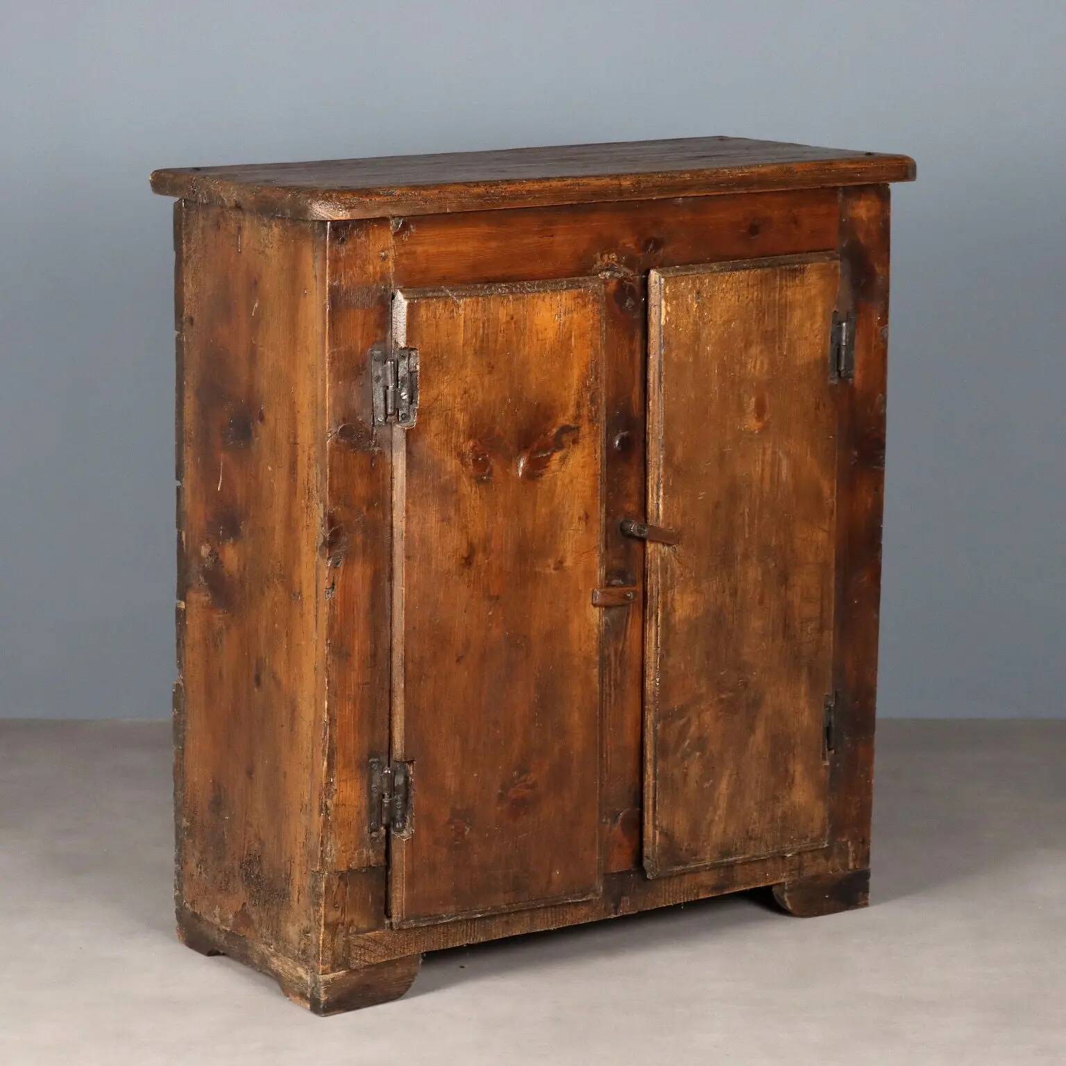 Antique pine wardrobe painted in walnut stain, restorations, Italy, 17th century.