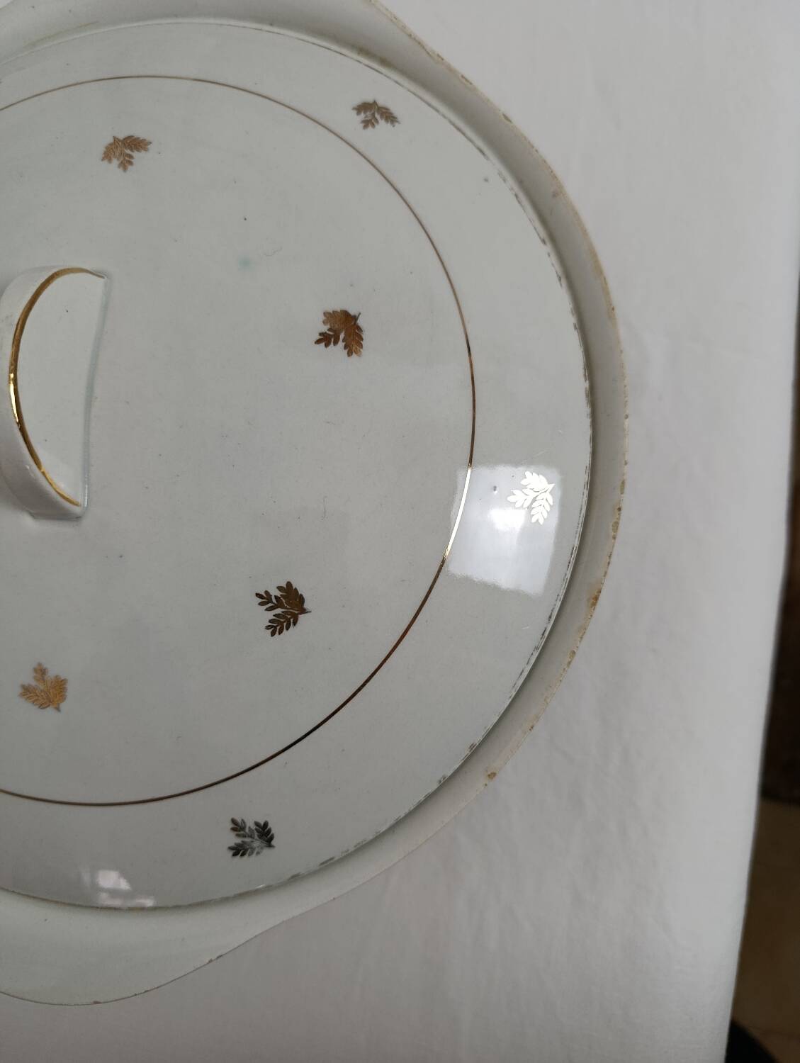 White earthenware soup tureen with a golden pattern.