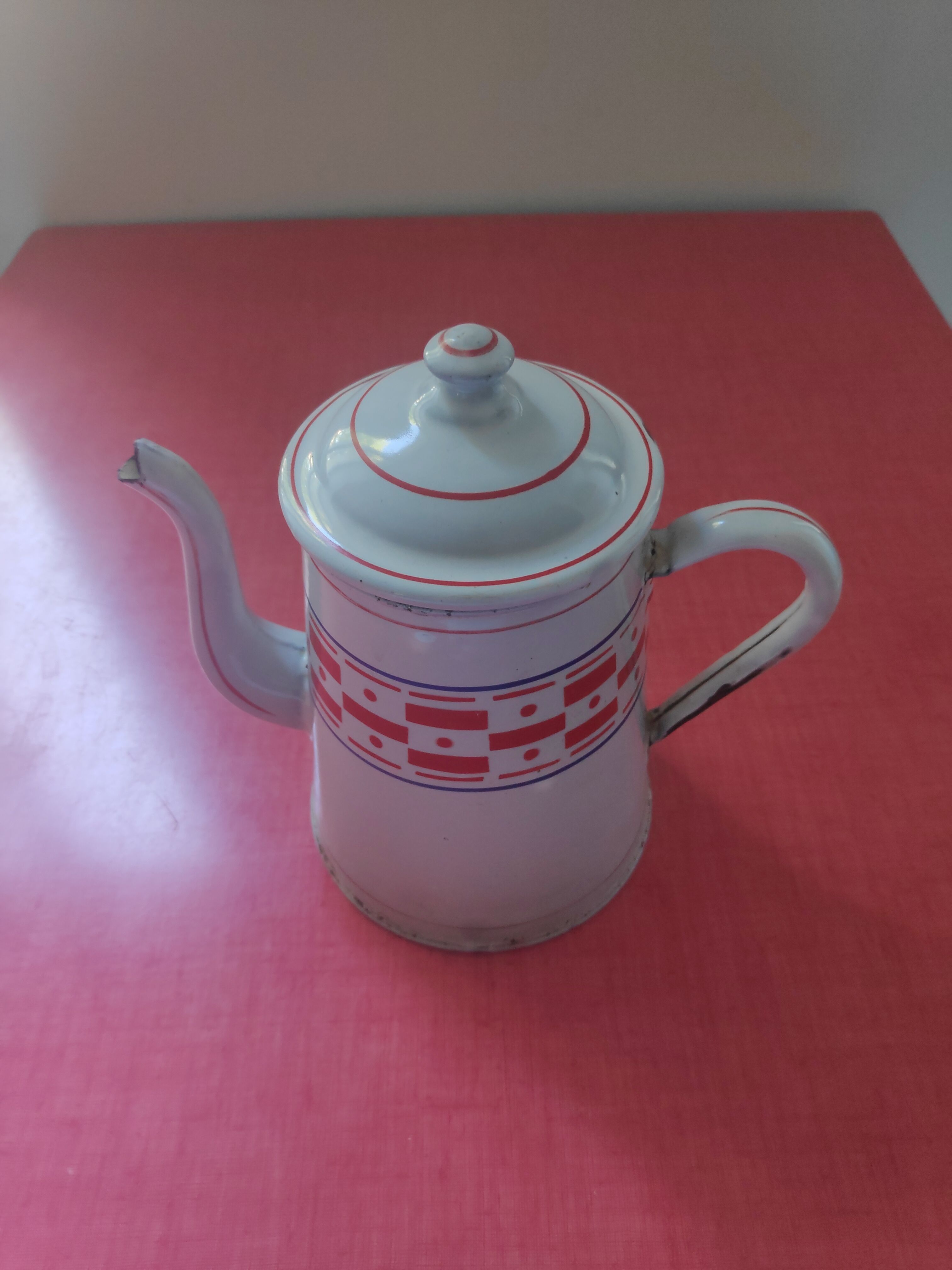 White enamelled sheet metal coffee maker with red and blue patterns