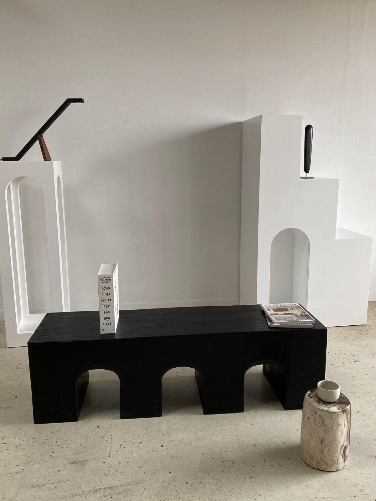 Black solid monoxyl wood bench carved into 3 arches