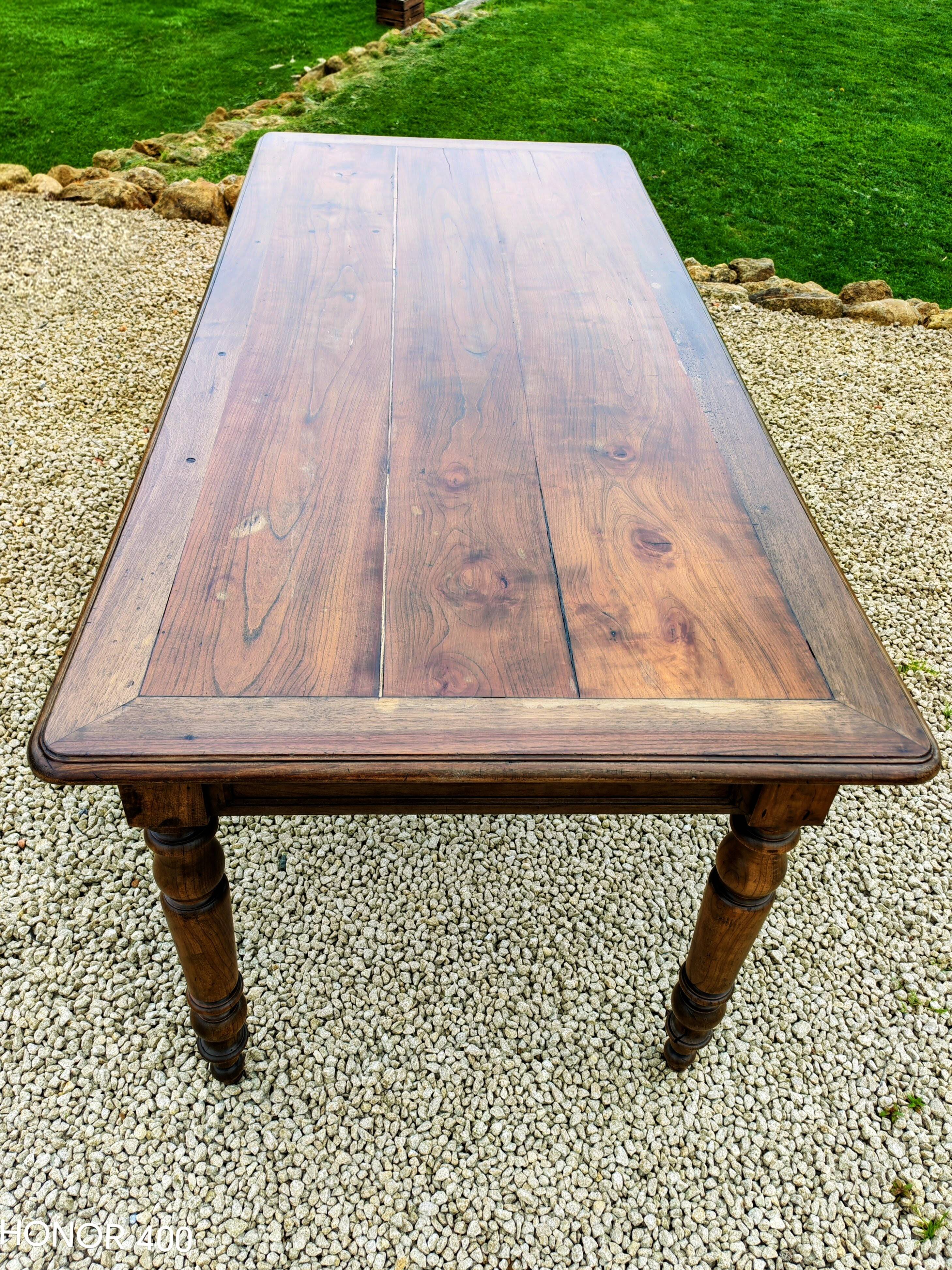 Old French farmhouse table in walnut with turned legs.