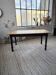 Oak farmhouse table with turned black legs.