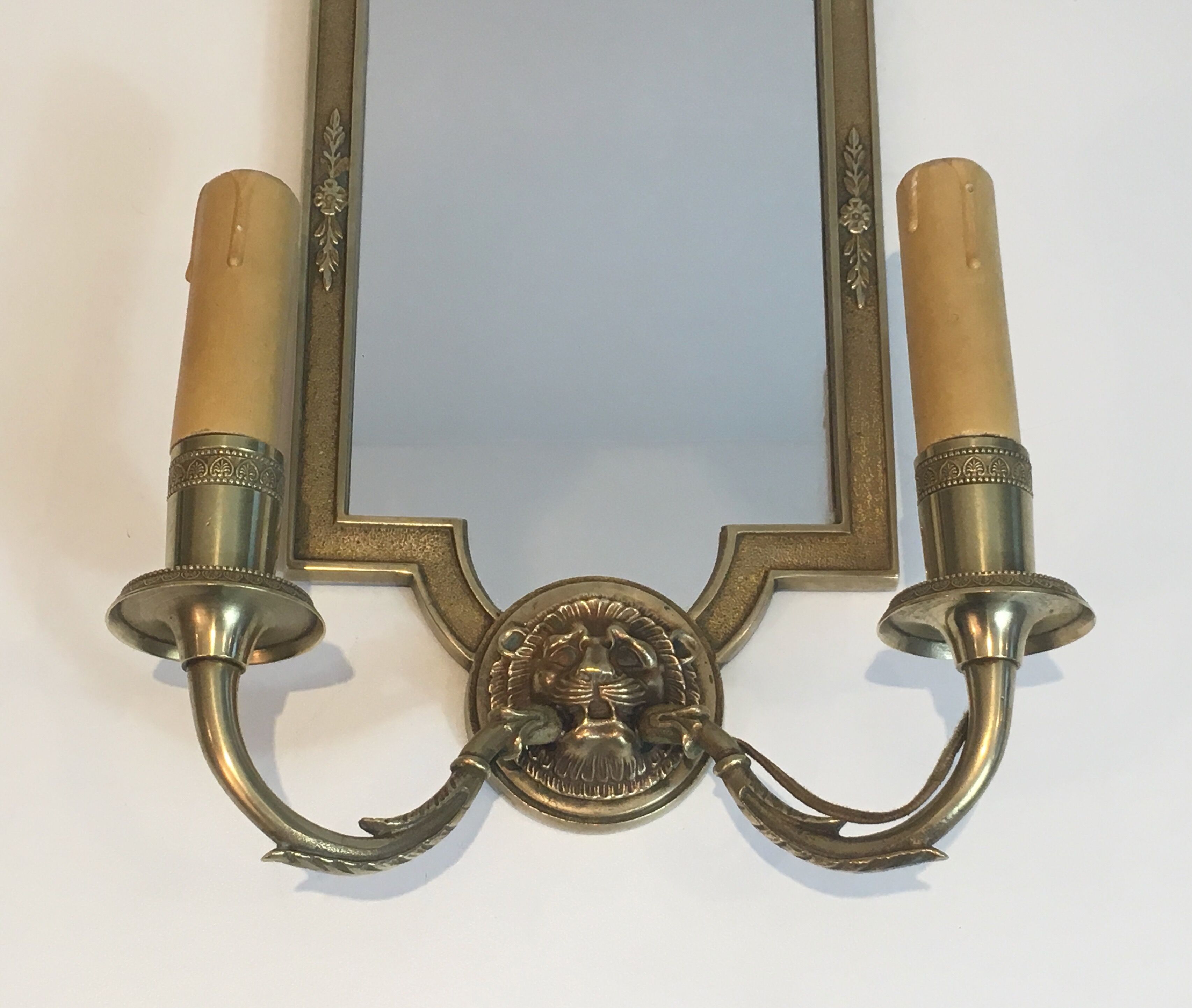 Pair of mirror and bronze wall lamps with lions' heads, french work. around 1940