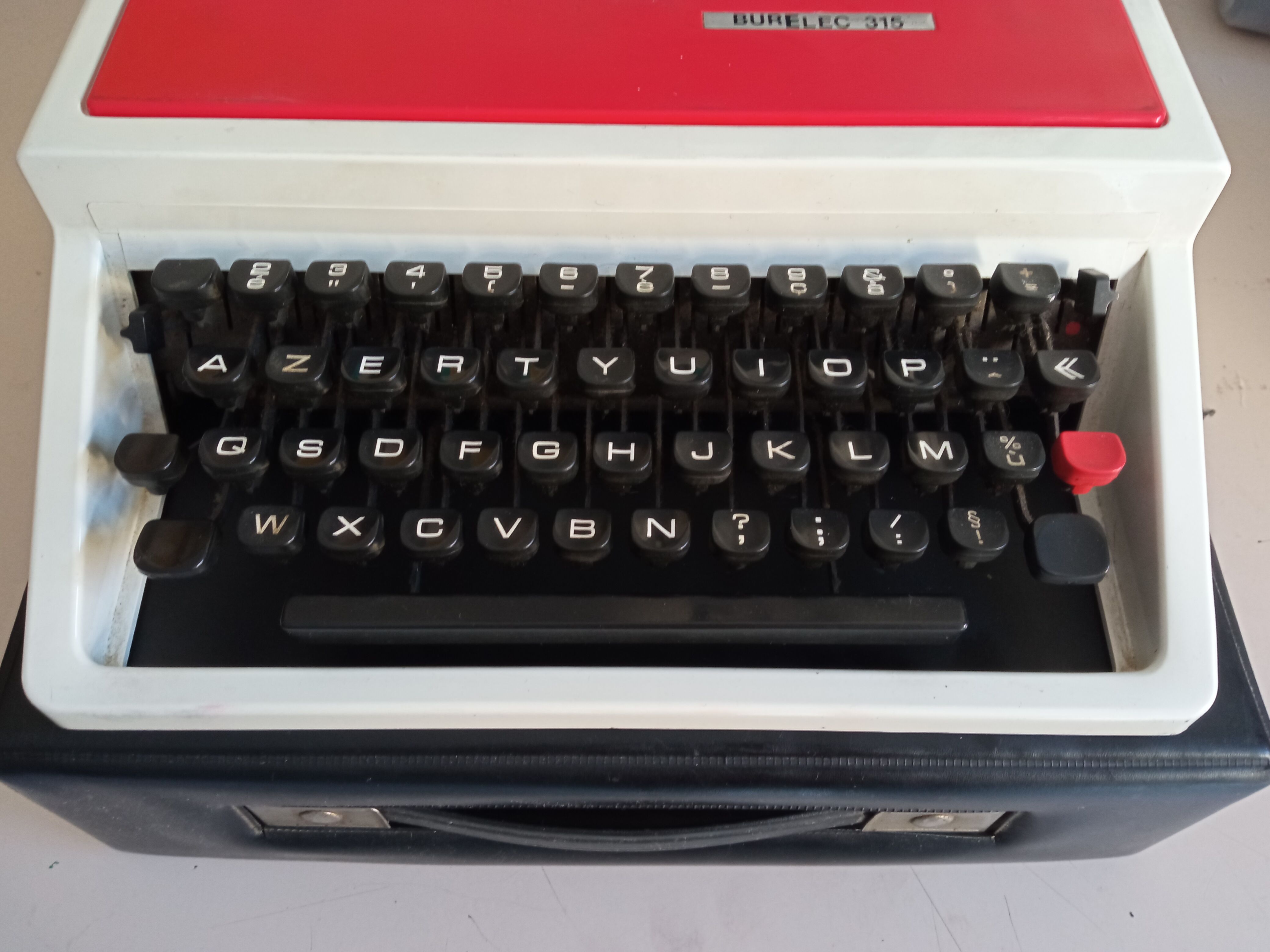 Typewriter "Burelec 315" made in Spain in red and white metal.