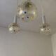 Vintage multicoloured glass sphere ceiling light with red dots and metal structure.