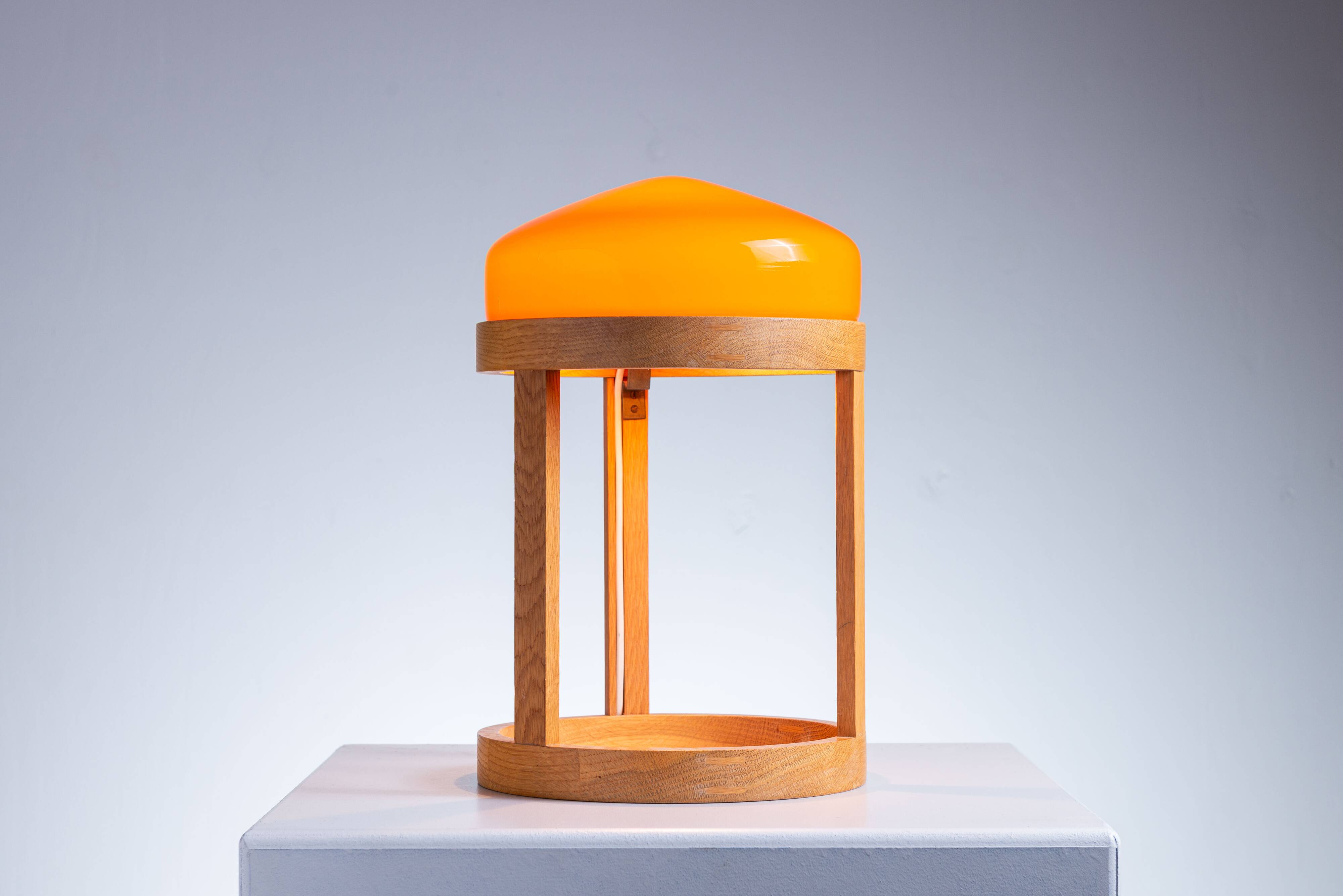 Bent oak wood table lamp with orange glass shade