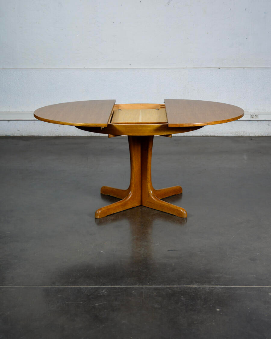 Round teak table with an extension.
