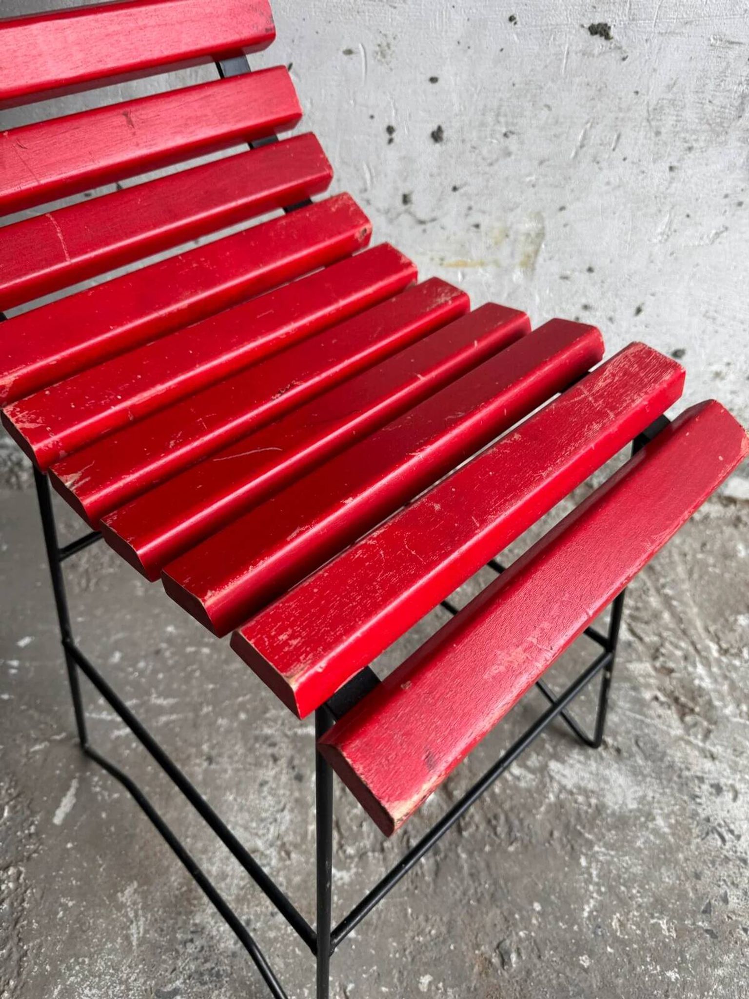 Red slatted chair with a black metal frame.