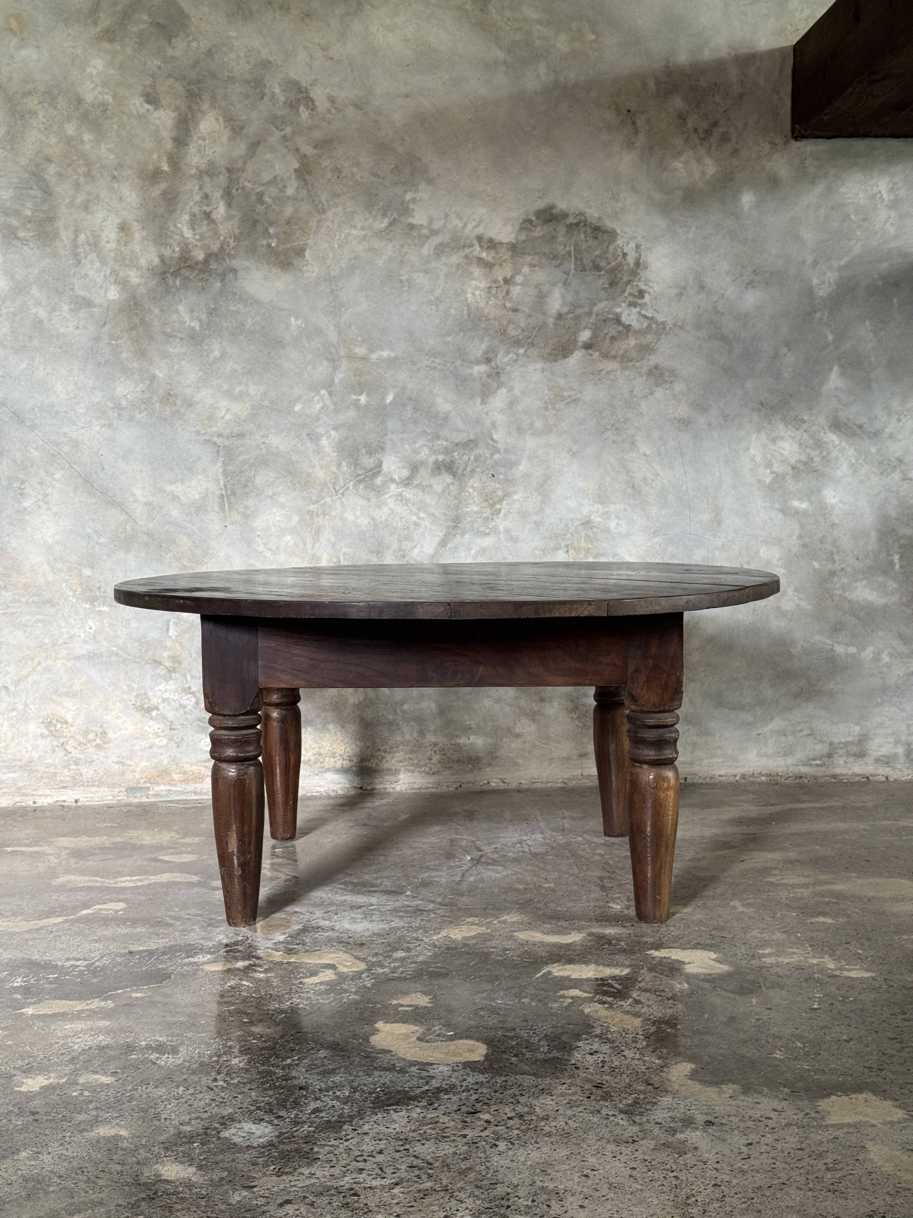 Coffee table, round antique Indonesian teak table with straight legs.