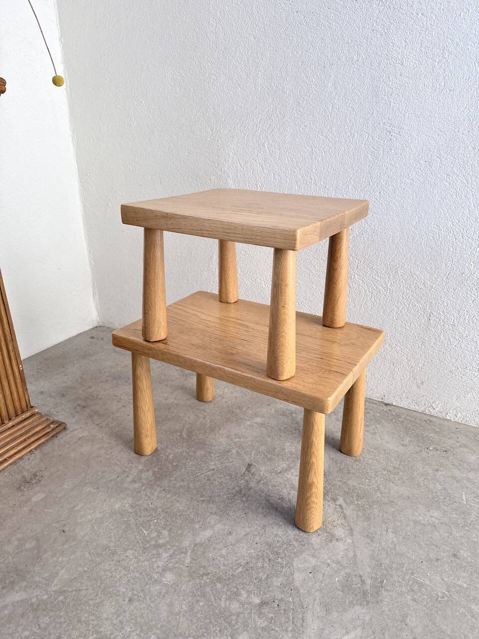 Two stools or small nesting tables in light oak.