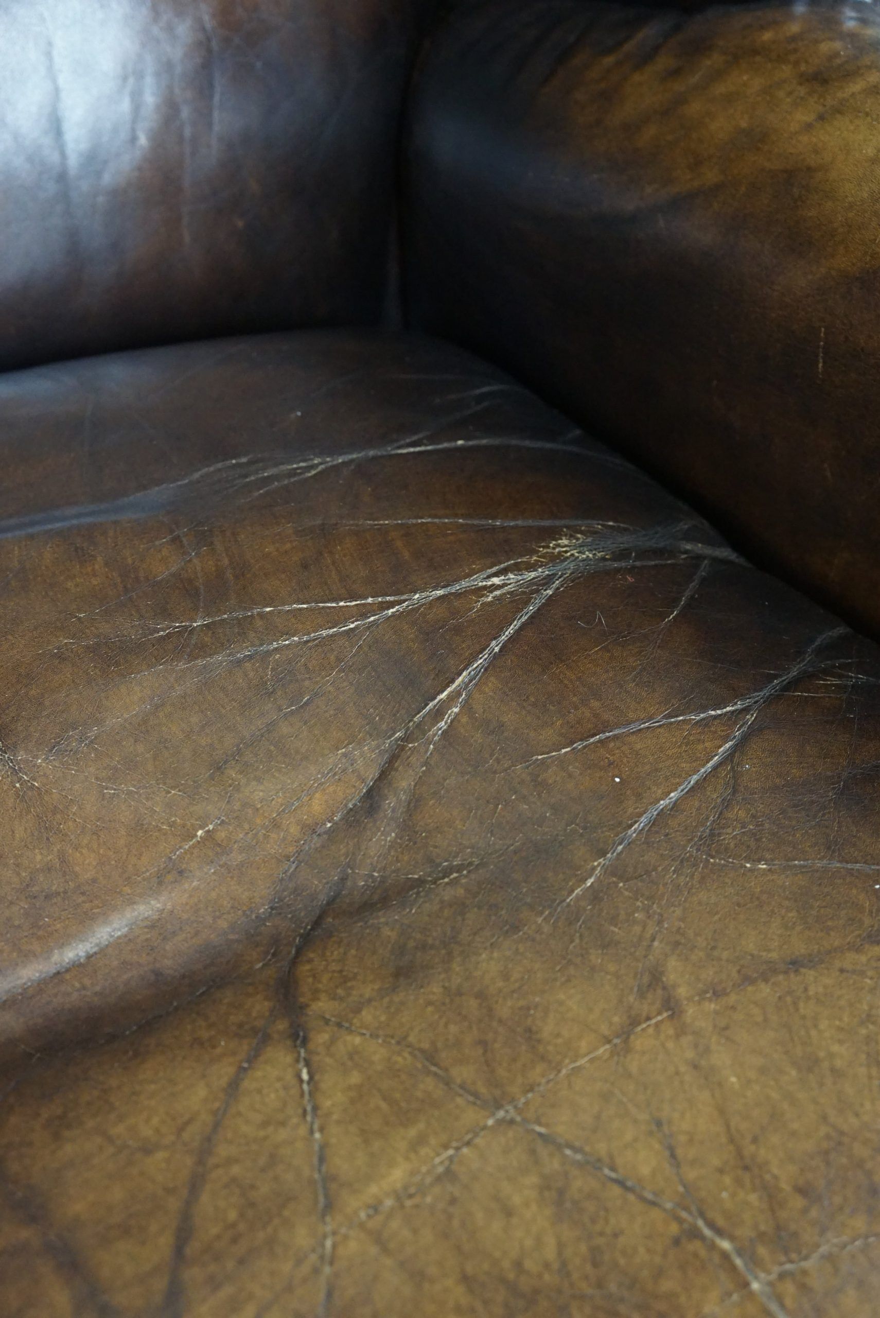 Patinated cowhide leather armchair