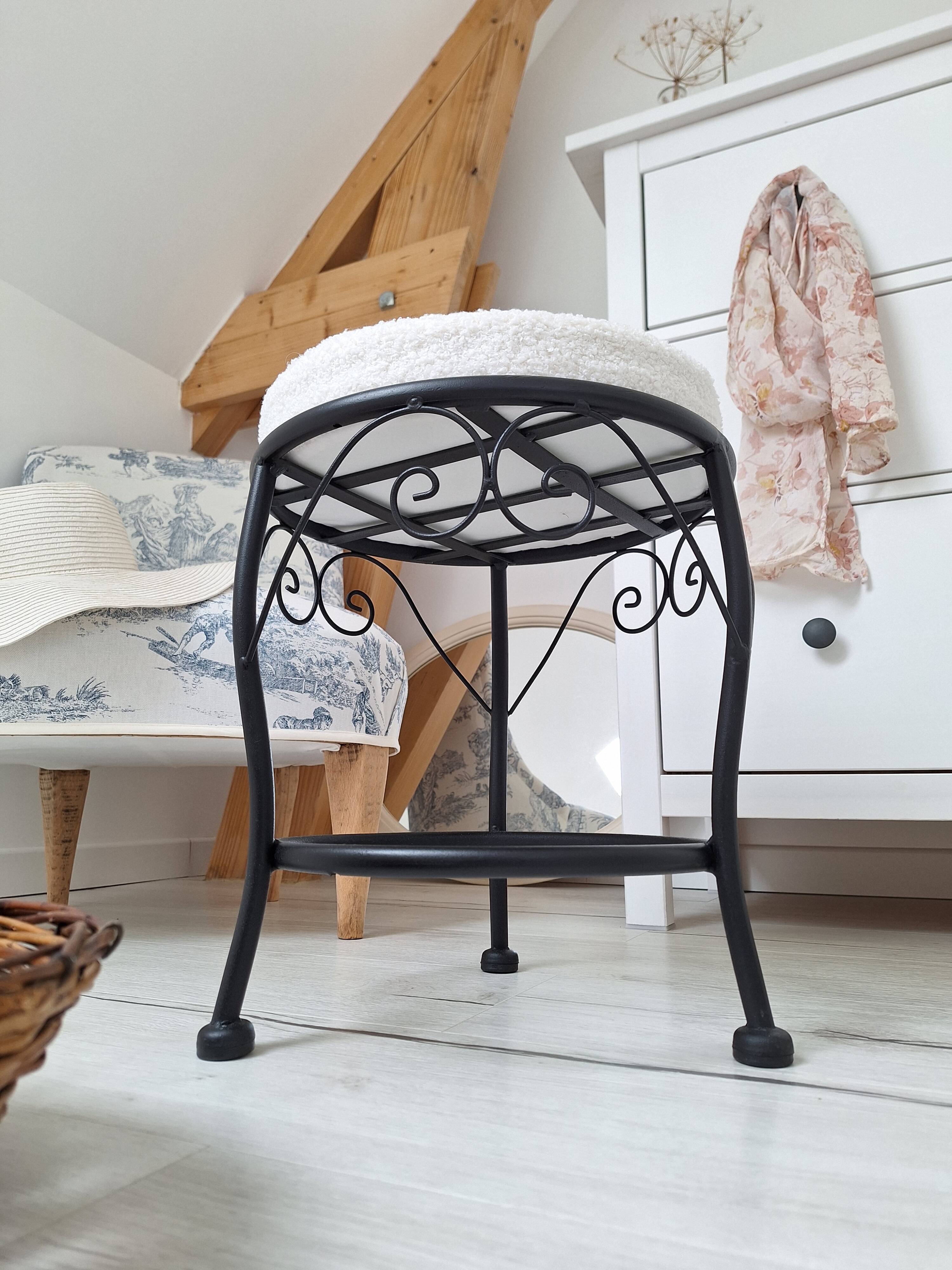 Black iron stool/pouf with its boucle fabric cushion.