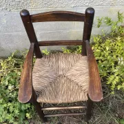 Vintage wooden children's high chair with straw.