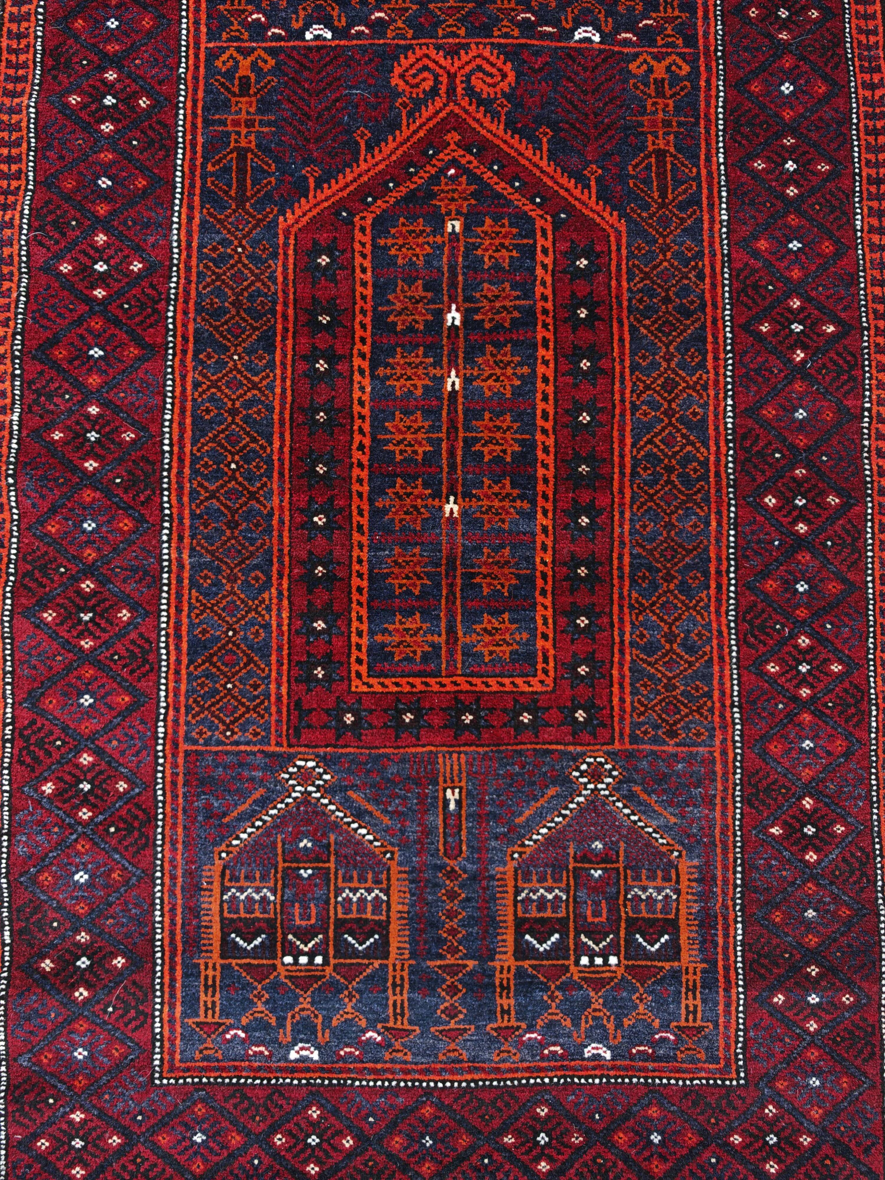 Vintage hand-knotted Persian Baluch prayer rug from the 1940s.